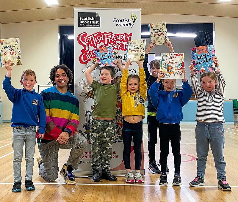 School pupils posing with children's laureate, Joseph Coelho, on the Scottish Friendly Children's Book Tour